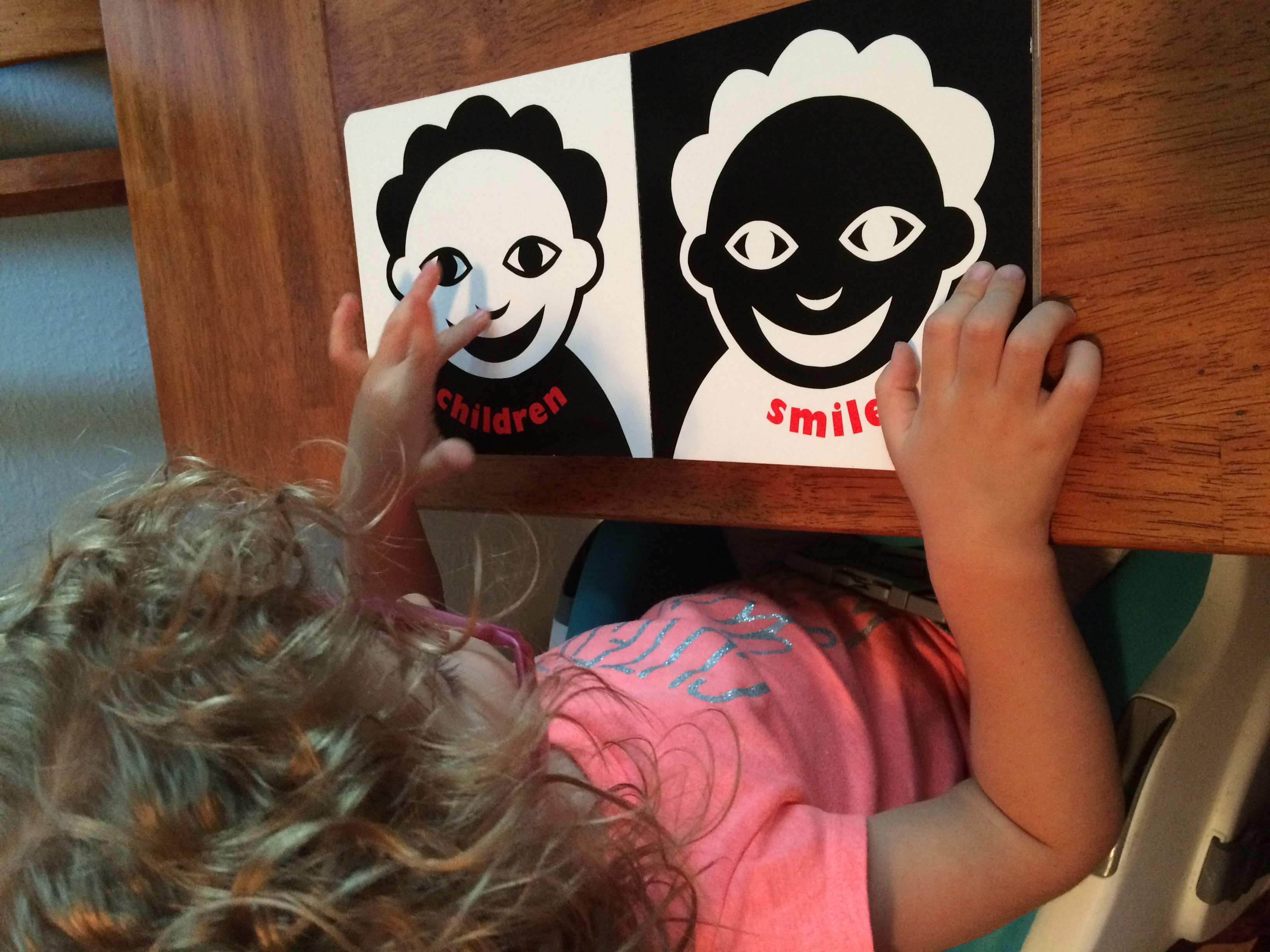 picture of olivia with black and white contrast images on cards of two faces that say smile