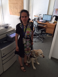 picture of Amy Liu in her office standing with her guide dog Donna.
