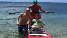 kim on the paddleboard in the ocean with ron and her friend next to her