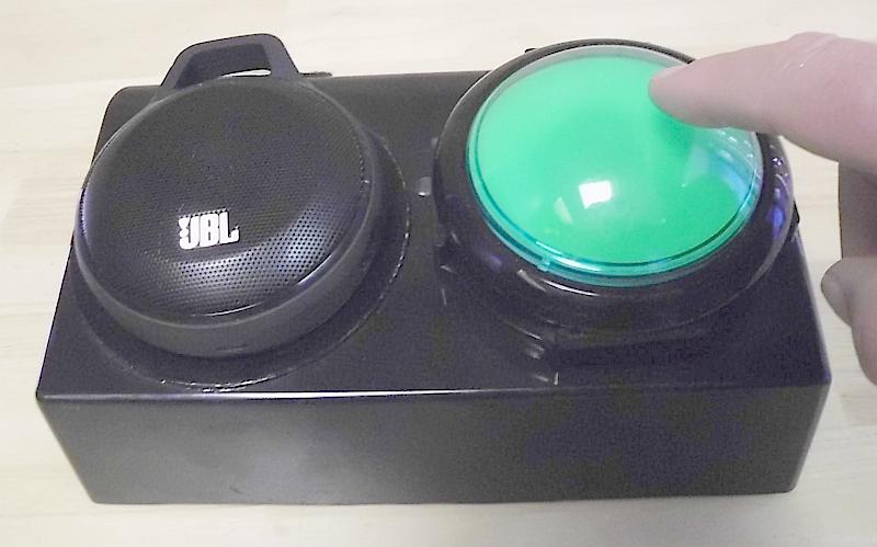 black box size of a small speaker with on speaker and one green switch button.