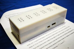 White box sitting on top of a typed document, top of box 6 groups of 6 retractable pins 