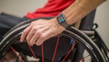 The torso of a man sitting in a wheelchair is shown, he is using the Apple watch wheelchair workout