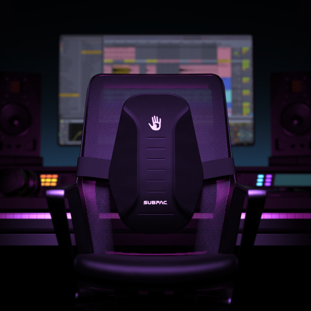 A Subpac attached to a chair with a monitor in the background.