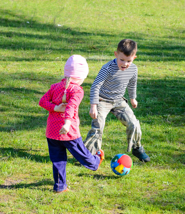 Two children play with a brightly colored ball.