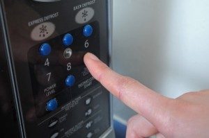 picture of a standard microwave touch screen with raised blue dots making the microwave accessible for blind individuals