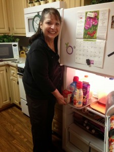 Bobbette standing in front of refridgerator pulling out a tray of creamers from the top shelf