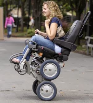 Woman on a wheelchair on 2 wheels outdoors