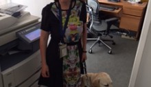 picture of Amy Liu in her office standing with her guide dog Donna.
