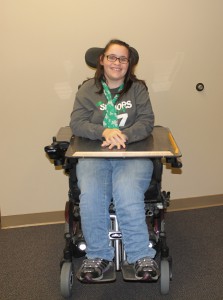 Photo of young women sitting in a power chair smiling 