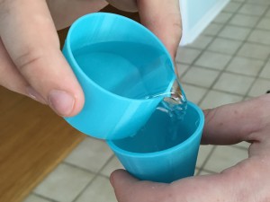blue printed cups holding water 