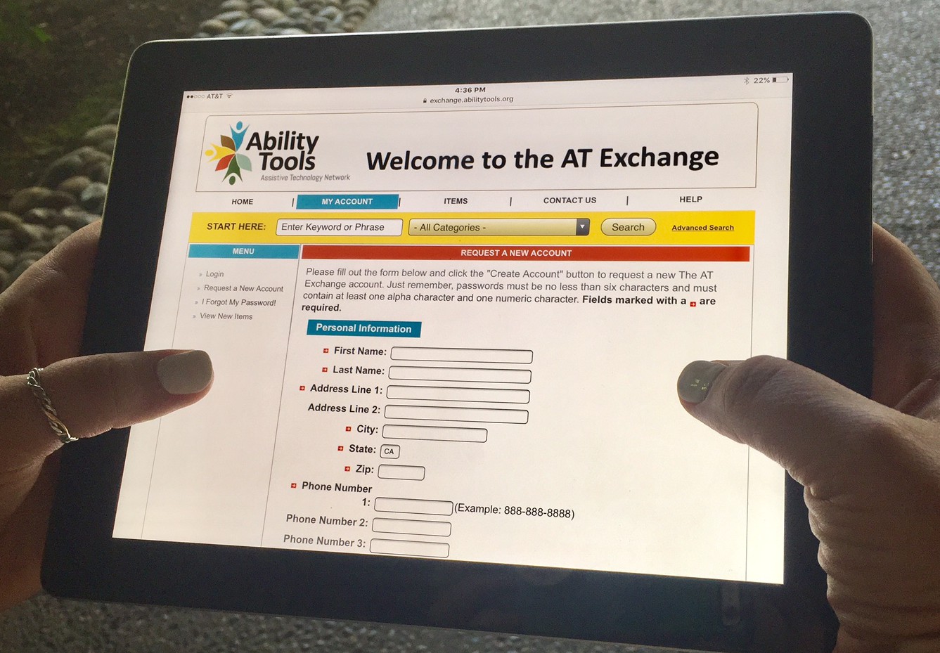 hands holding up an ipad displaying the "AT Exchange new account" page 