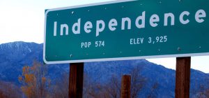 Green Road sign that reads "Independence, Pop. 574, Elev 3,925