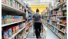 women and service dog walking down the aisle in a grocery store