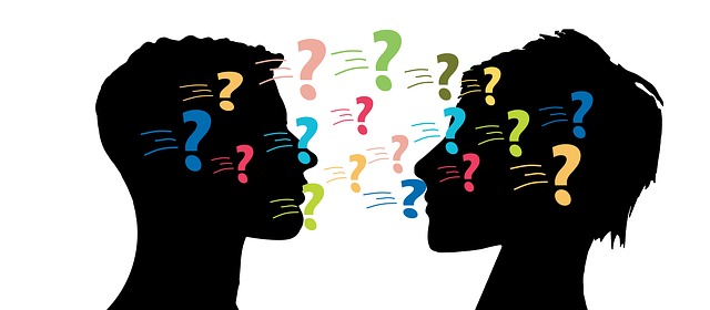 Two silhouettes or people facing each other and colorful question marks being passed back and forth 