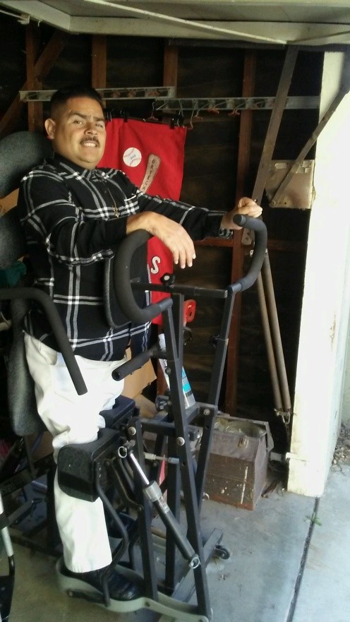 A man is using an adapted device to help him to stand.