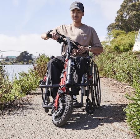 A wheelchair user taking his firefly on a riverside trail.