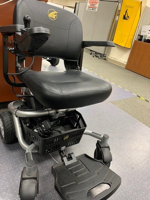 A LiteRider Envy Electric wheelchair in an office filled with desks and cubicle dividers.