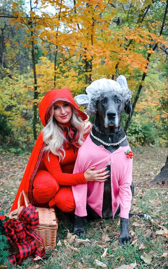 Lifestyle Blogger Hayden M. Ward poses for a photo. She is dressed in a Red Riding Hood Costume and her dog is dressed as Big Bad Wolf disguised as Grandma. 